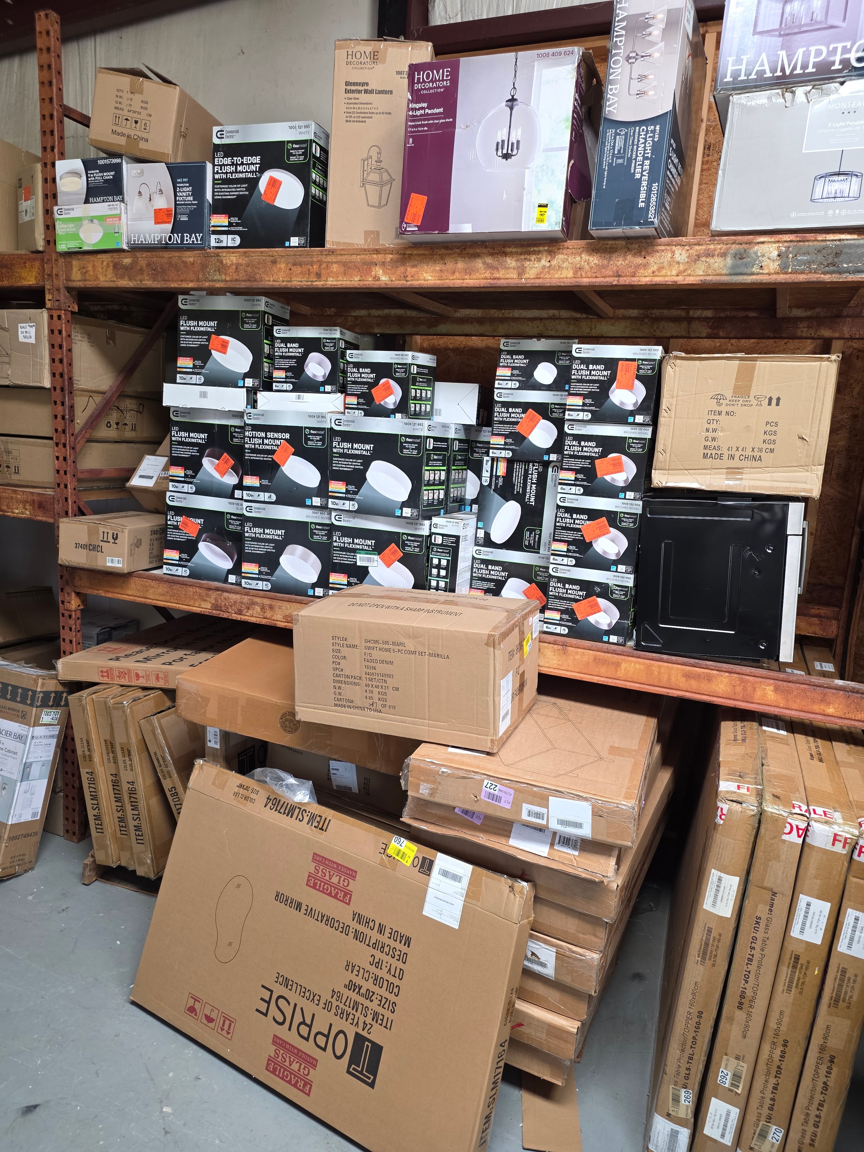 Hampton Bay lighting fixtures and flush mounts on warehouse shelves