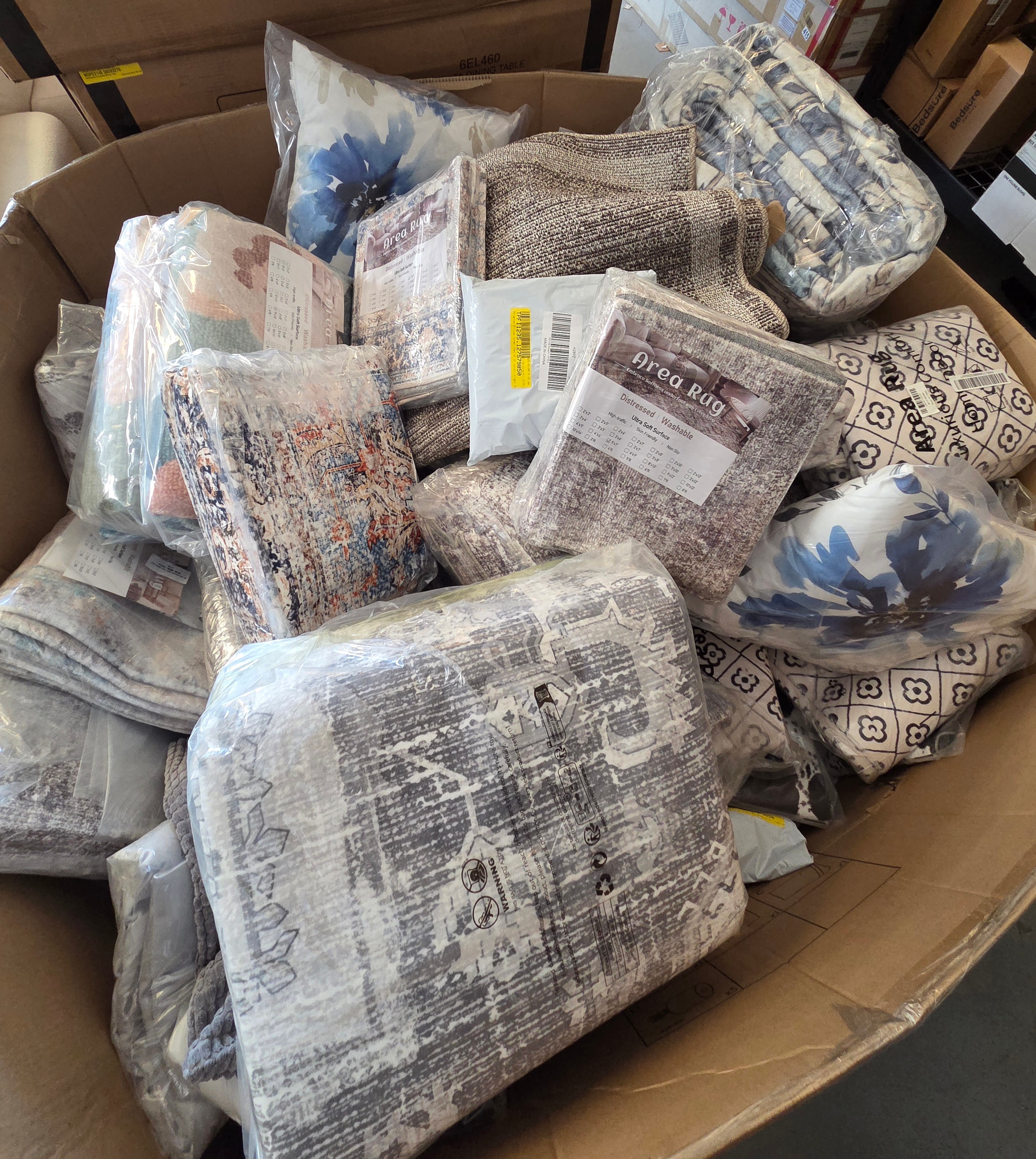 Area rugs and pillows in warehouse bin